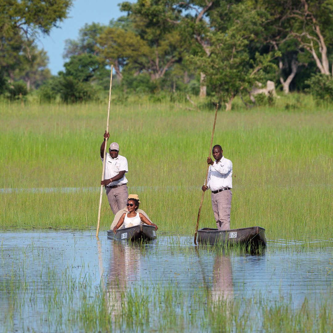 Polers steering mokoros across a channel at Karangoma